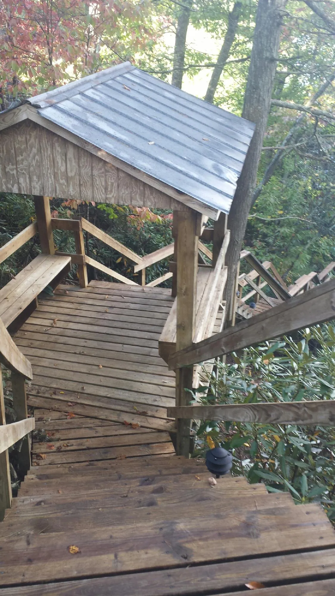 Metal roofed shelter over wooden steps on a wooded walkway — Skylight Repair & Installation work by our crew in Deer Park